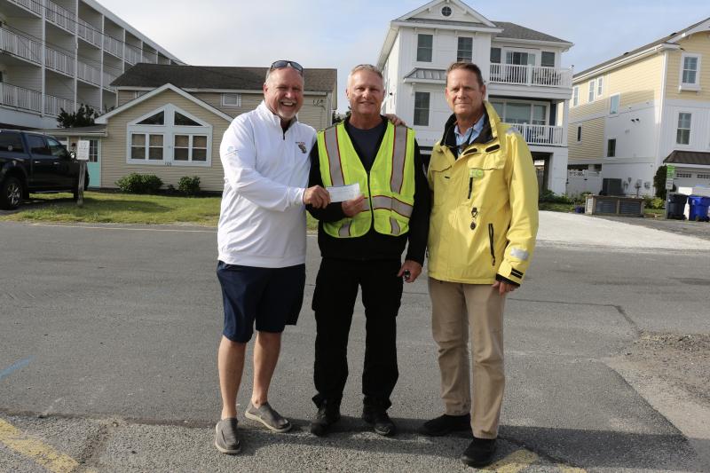 Rehoboth Beach Volunteer Fire Company Deputy Chief Ken Swartz, center, accepts a $250 donation from Commissioner Paul Bauer, left, and Town Manager Bill Zolper as thanks for their assistance.